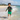 6-8 year old Asian boy running through waves in Play Robo rash guard