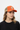 Female model close-up wearing orange trucker hat looking to side