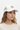 Female model close-up wearing white trucker hat looking to side
