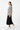 Female model in black midi skirt and white sneakers