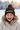 Girl age 7 wearing black pom-pom beanie