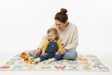 Parent teaching child with ABC blanket white background