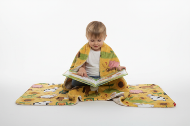 Child reading farm book with blanket white background