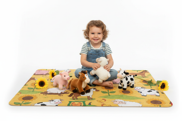 Child playing with stuffed animals on farm blanket white background