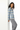 Leaning casually with gray pants