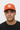 Male model close-up wearing orange trucker hat looking up