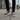Man wearing colorful lace-ups with black jeans on concrete