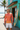 Standing outside surf shop with surfboard