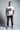 White tee with tattooed model, one hand in pocket