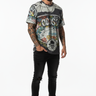 All-over print tee with tattooed model, one hand in pocket