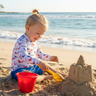 Boy at beach building sandcastle