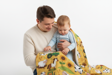 Parent and child cuddling with farm blanket white background