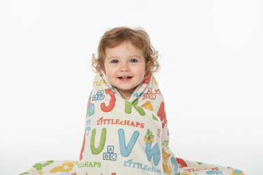Toddler wrapped in ABC learning blanket white background